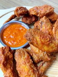 fried chicken wings with sauce on a wooden plate